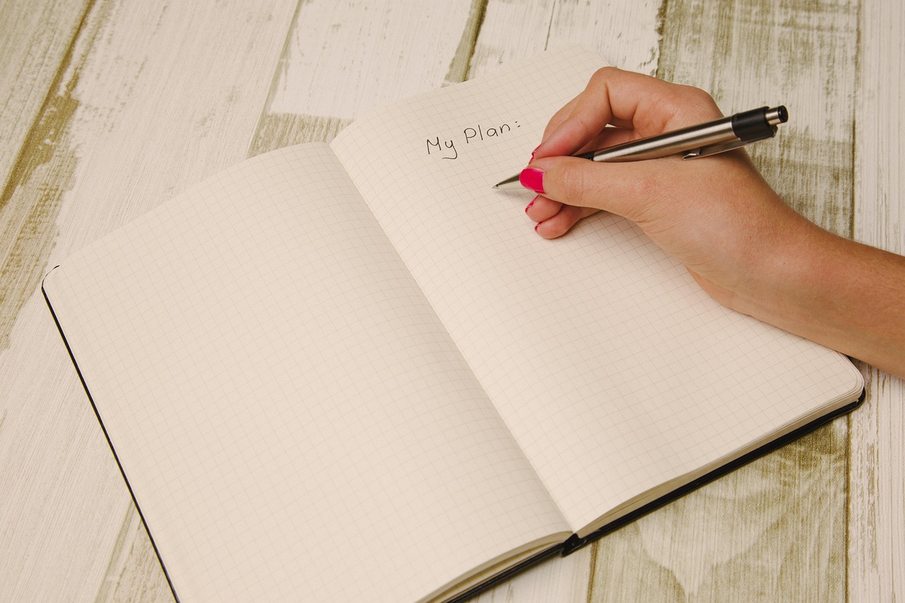 Hand writing a plan in a notebook — outlining your novel