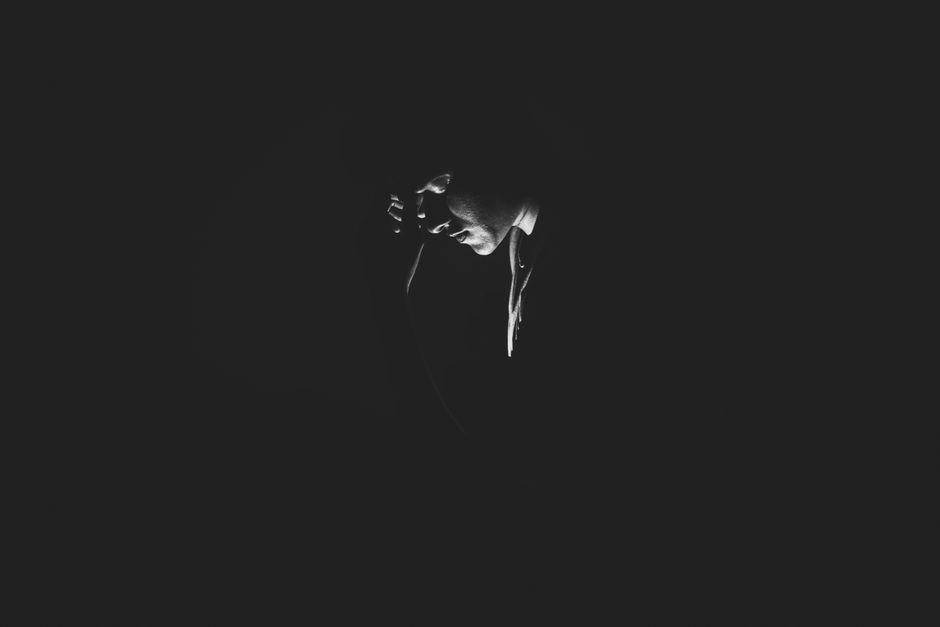 A solitary man is captured in a black and white moody setting, evoking feelings of loneliness and introspection.