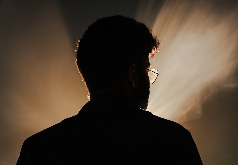 Artistic silhouette portrait with dramatic backlight creating a mysterious and moody atmosphere.