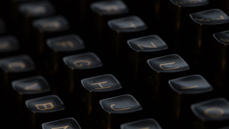 Artistic close-up of vintage typewriter keys highlighting letters with a shallow depth of field.